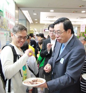 梁君彥邀請街坊品嚐燒豬肉,與他們共享辦事處開幕的喜悅。