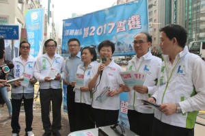 政務司司長林鄭月娥率領大家齊心高喊口號。從左到右依次為：經民聯區議員李 祺逢，經民聯副主席盧偉國博士，財經事務及庫務局局長陳家強教授，立法會議 員梁美芬博士，林鄭月娥司長，深水埗區議會主席郭振華，以及經民聯地區事務 召集人張俊勇。