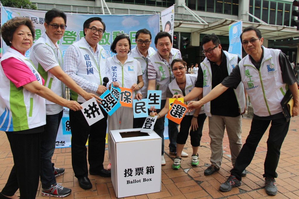 經民聯一眾成員將印有「拼經濟 保民生 登記做選民」紙牌放進模擬投票箱，呼籲巿民為香港經濟民生，登記做選民後用手中一票回復議會秩序。